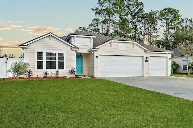 view of front of property with a yard and a garage