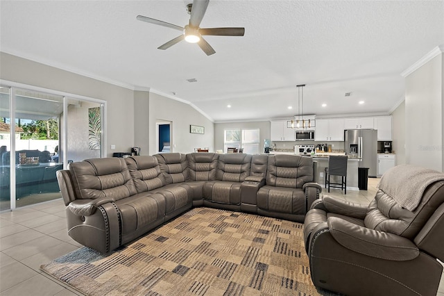 tiled living room with a textured ceiling, ceiling fan, lofted ceiling, and ornamental molding