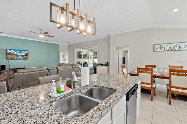 kitchen featuring sink, vaulted ceiling, stainless steel dishwasher, decorative light fixtures, and white cabinetry