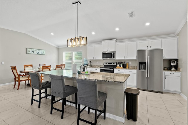 kitchen featuring white cabinetry, crown molding, vaulted ceiling, a kitchen island with sink, and appliances with stainless steel finishes