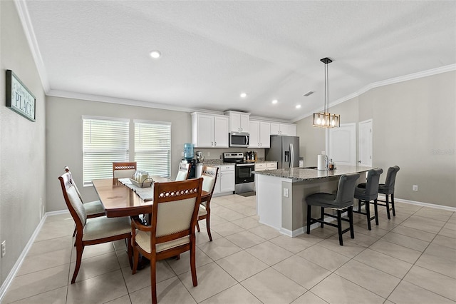 kitchen with light stone countertops, appliances with stainless steel finishes, crown molding, white cabinets, and a kitchen island