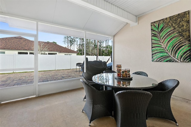 sunroom with vaulted ceiling with beams