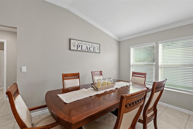 dining room featuring a textured ceiling, light tile patterned floors, vaulted ceiling, and ornamental molding