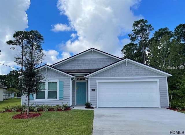 view of front of home with concrete driveway, an attached garage, and a front lawn