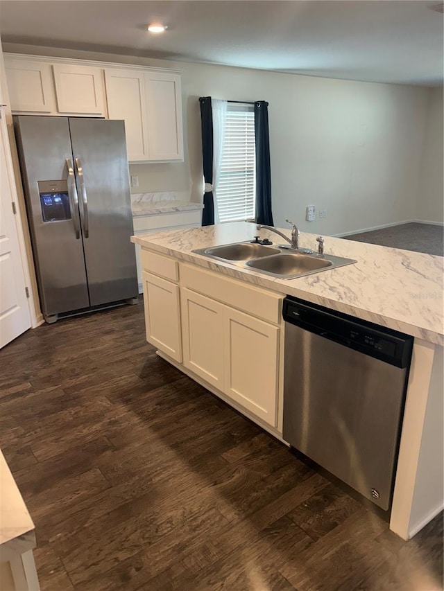 kitchen featuring stainless steel appliances, white cabinetry, and a sink