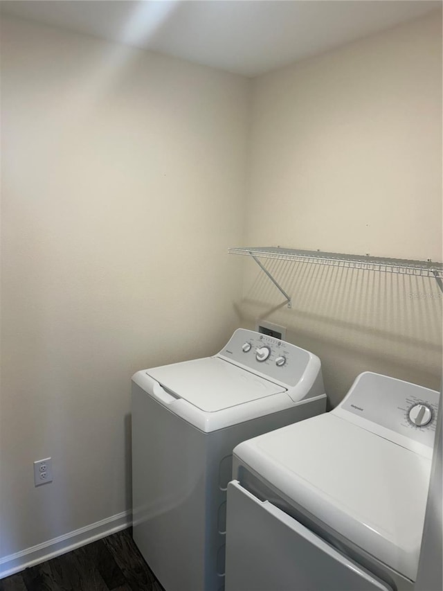 laundry room with laundry area, baseboards, separate washer and dryer, and dark wood-type flooring