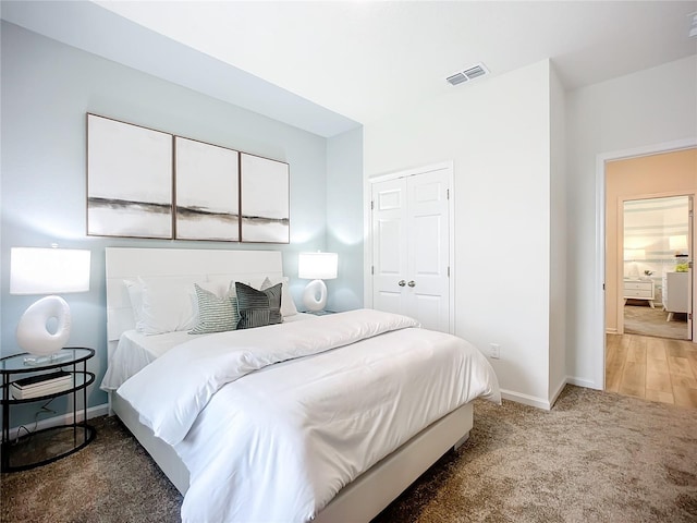 bedroom with dark hardwood / wood-style floors and a closet