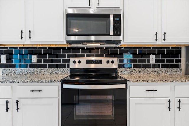 kitchen featuring light stone countertops, stainless steel appliances, and white cabinetry