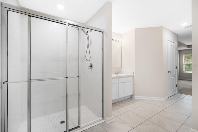 bathroom with tile patterned flooring, vanity, and a shower with door