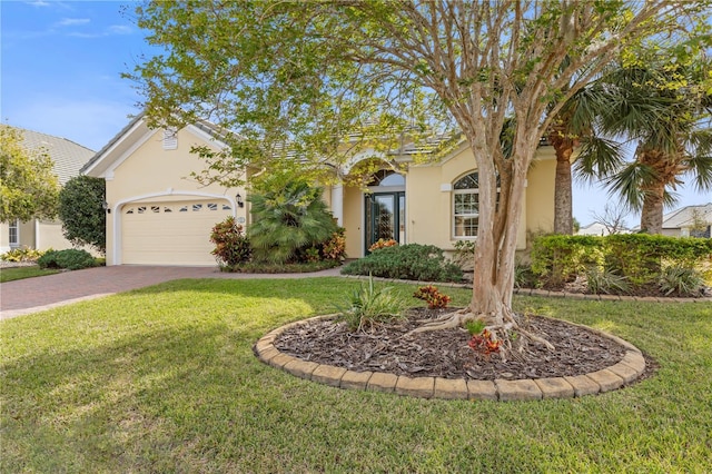 view of front of property with a garage and a front lawn