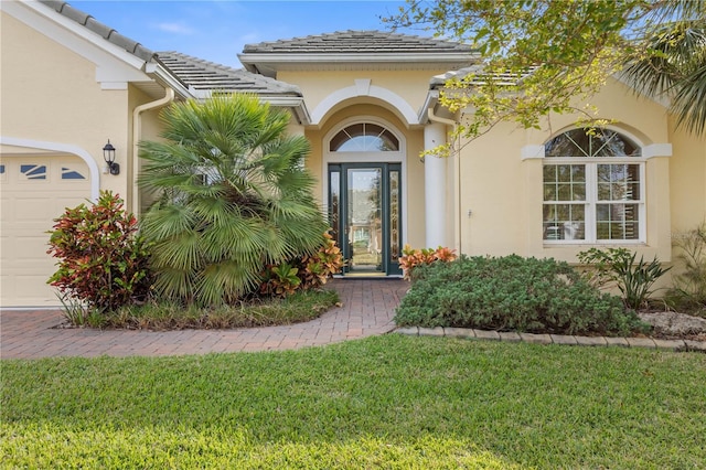 doorway to property featuring a yard and a garage