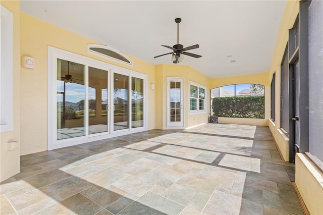 unfurnished sunroom featuring plenty of natural light and ceiling fan