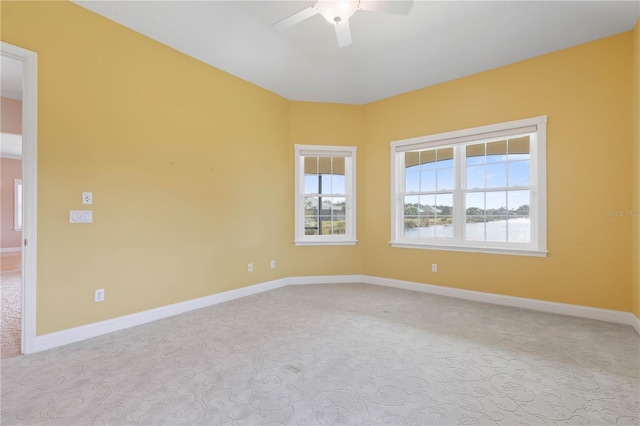 carpeted spare room with ceiling fan