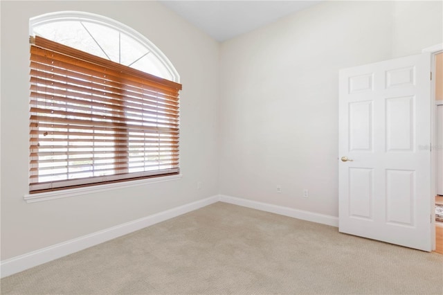 unfurnished room featuring light carpet