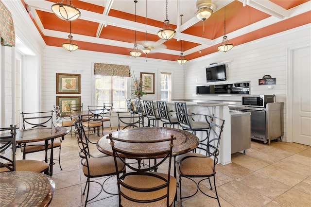 dining space with a tray ceiling and coffered ceiling