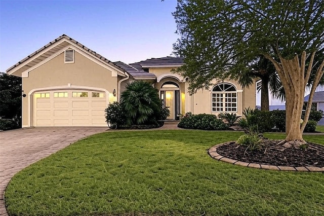 88 Longview Way N, Palm Coast, FL 32137 - view of front of property featuring an attached garage, decorative driveway, stucco siding, a yard, and a tiled roof