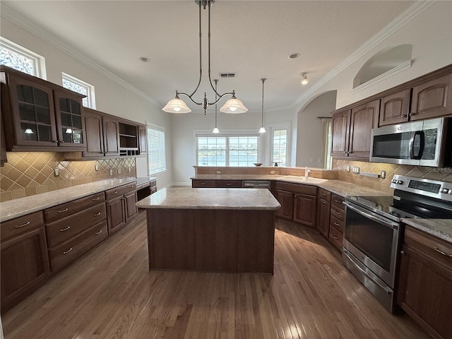 88 Longview Way N, Palm Coast, FL 32137 - kitchen with stainless steel appliances, a sink, wood finished floors, dark brown cabinetry, and decorative backsplash