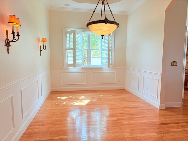 88 Longview Way N, Palm Coast, FL 32137 - unfurnished dining area featuring ornamental molding, light wood-style flooring, a wainscoted wall, and a decorative wall