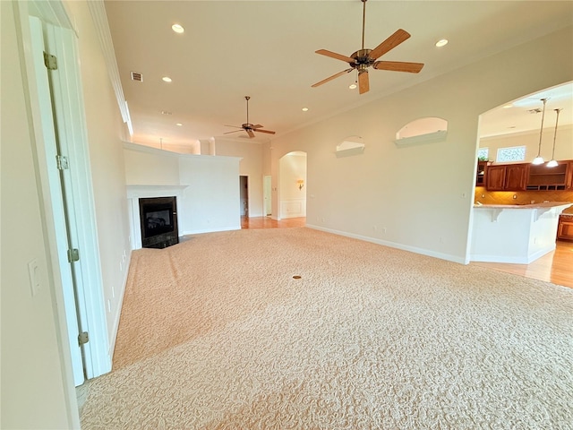 88 Longview Way N, Palm Coast, FL 32137 - unfurnished living room with arched walkways, a ceiling fan, light carpet, recessed lighting, and a glass covered fireplace