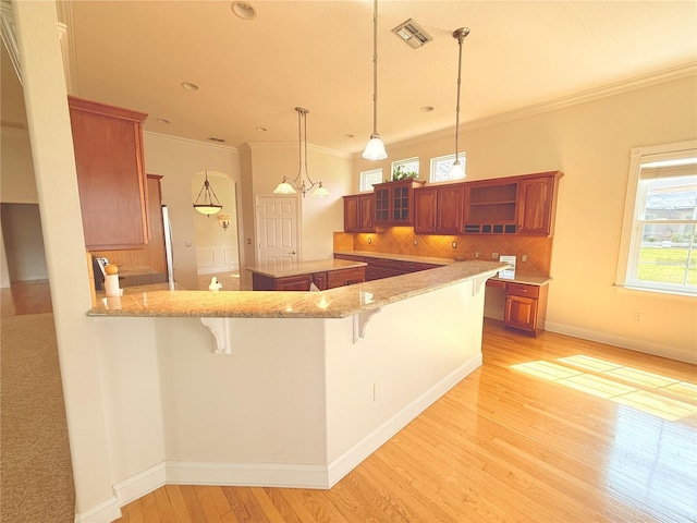 88 Longview Way N, Palm Coast, FL 32137 - kitchen with brown cabinetry, light wood-style flooring, a breakfast bar, open shelves, and tasteful backsplash