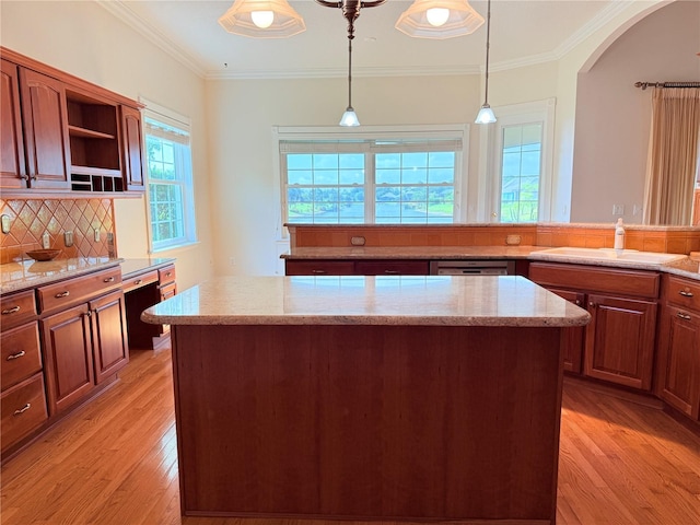88 Longview Way N, Palm Coast, FL 32137 - kitchen with a sink, light wood-style flooring, a center island, hanging light fixtures, and decorative backsplash