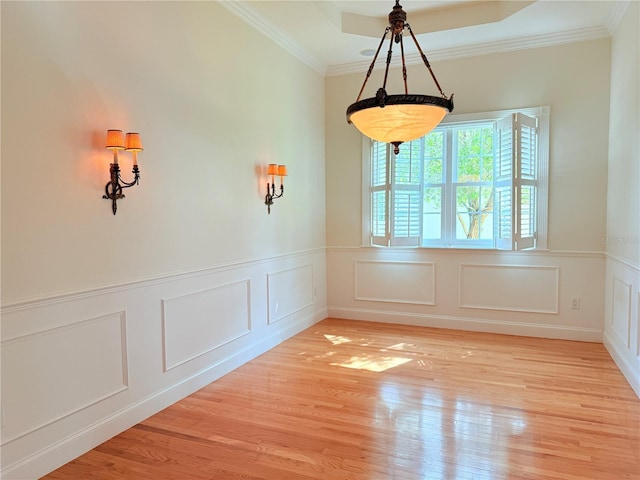 88 Longview Way N, Palm Coast, FL 32137 - unfurnished dining area featuring a decorative wall, light wood-type flooring, crown molding, wainscoting, and a tray ceiling
