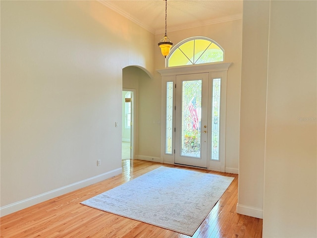 88 Longview Way N, Palm Coast, FL 32137 - entrance foyer featuring arched walkways, crown molding, light wood-style flooring, baseboards, and a towering ceiling
