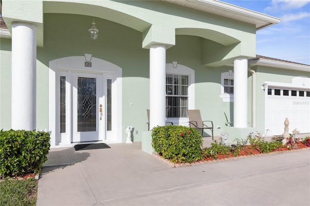 54 Fieldstone Ln, Palm Coast, FL 32137 - view of exterior entry with a porch, stucco siding, and an attached garage