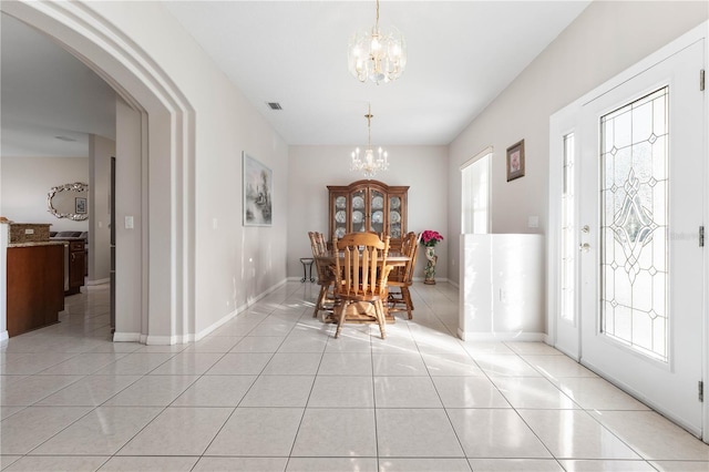 tiled dining room featuring an inviting chandelier