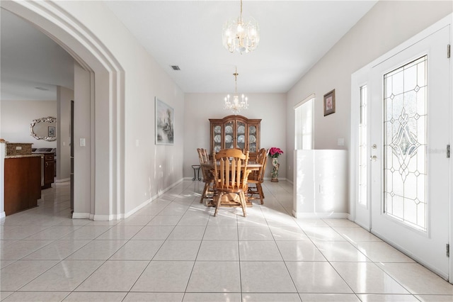 54 Fieldstone Ln, Palm Coast, FL 32137 - dining space featuring a chandelier, light tile patterned floors, and arched walkways