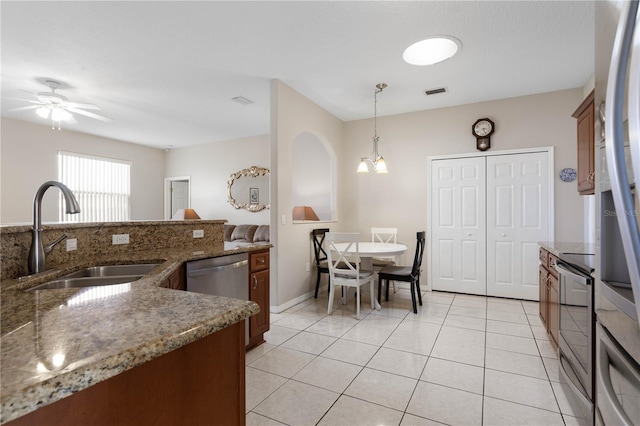 54 Fieldstone Ln, Palm Coast, FL 32137 - kitchen featuring stainless steel appliances, ceiling fan, hanging light fixtures, light tile patterned floors, and stone counters