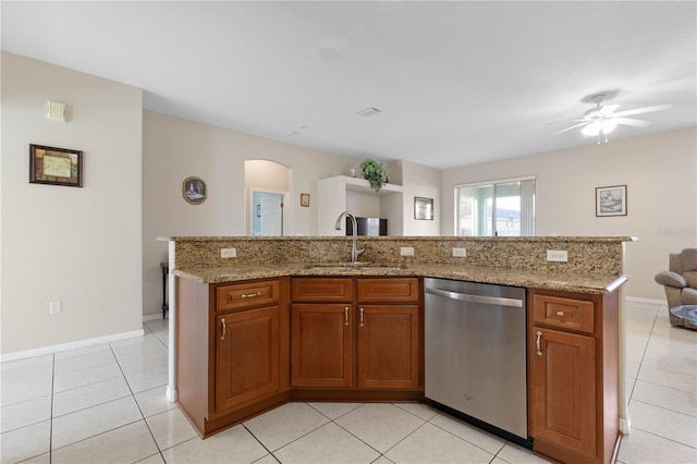 kitchen featuring stainless steel dishwasher, ceiling fan, light tile patterned floors, and a kitchen island with sink