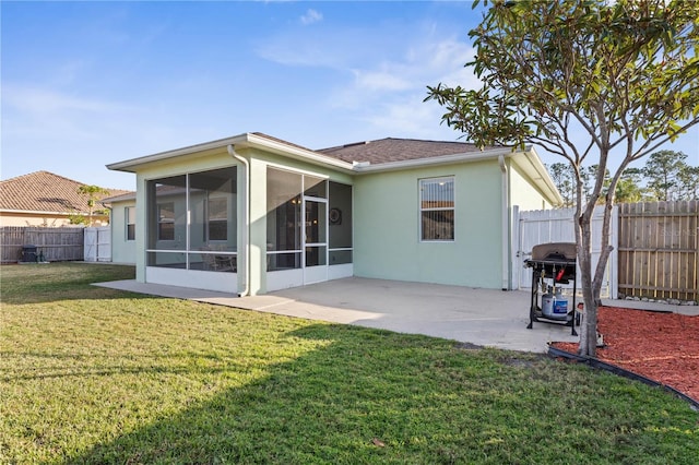 back of house featuring a lawn, a patio area, and a sunroom