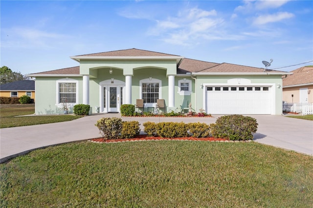 view of front of property with a garage, stucco siding, concrete driveway, and a front yard