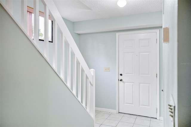 tiled foyer entrance with a textured ceiling