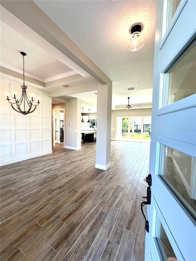 interior space featuring a textured ceiling, dark hardwood / wood-style flooring, and ceiling fan with notable chandelier