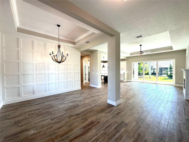 unfurnished living room with a textured ceiling, ceiling fan with notable chandelier, a raised ceiling, and dark wood-type flooring