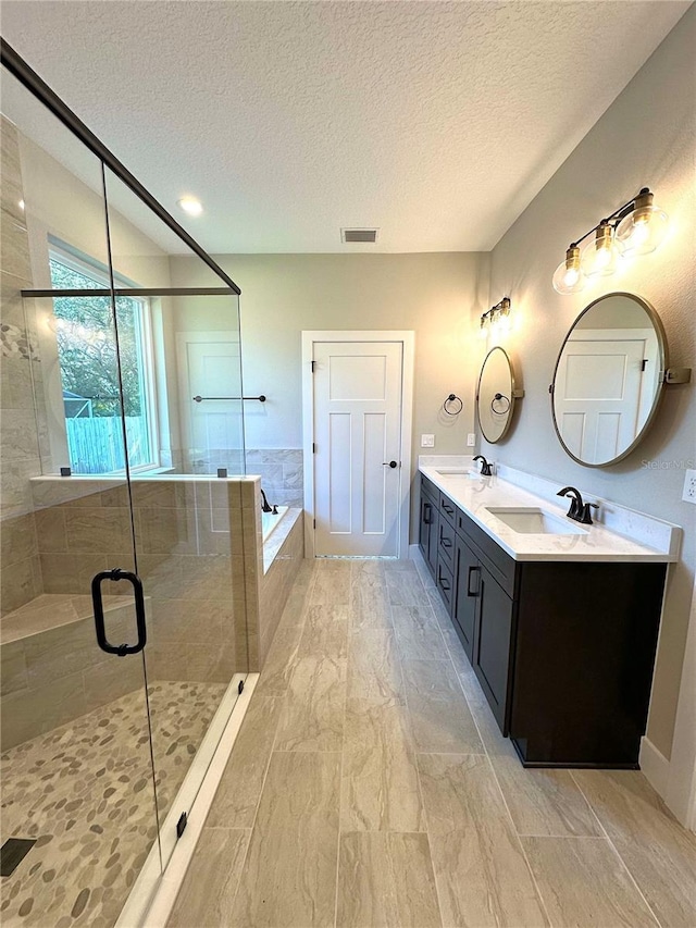 bathroom featuring vanity, plus walk in shower, and a textured ceiling