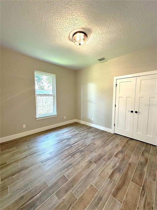 spare room with hardwood / wood-style flooring and a textured ceiling