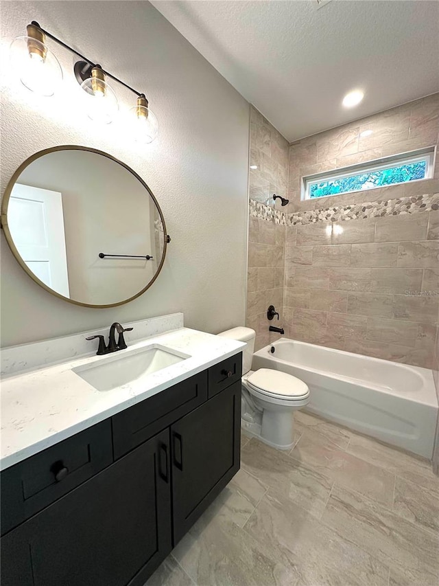 full bathroom featuring a textured ceiling, vanity, toilet, and tiled shower / bath