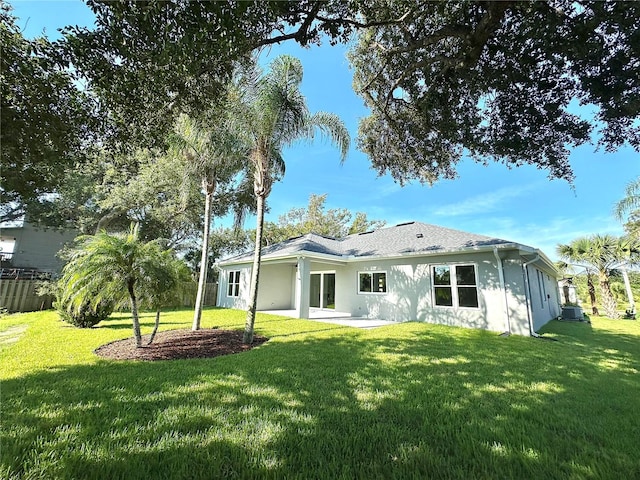 rear view of property featuring a yard and a patio