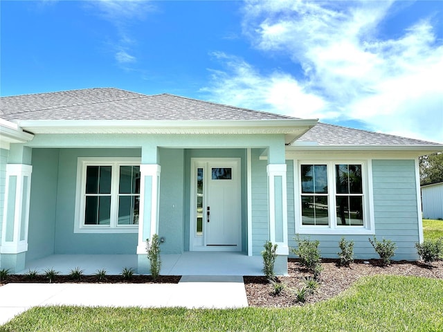36 Armand Beach Dr, Palm Coast, FL 32137 - entrance to property featuring a shingled roof and a porch