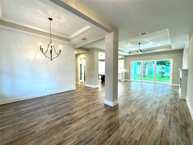 36 Armand Beach Dr, Palm Coast, FL 32137 - unfurnished living room with a raised ceiling, a chandelier, dark wood finished floors, and ceiling fan
