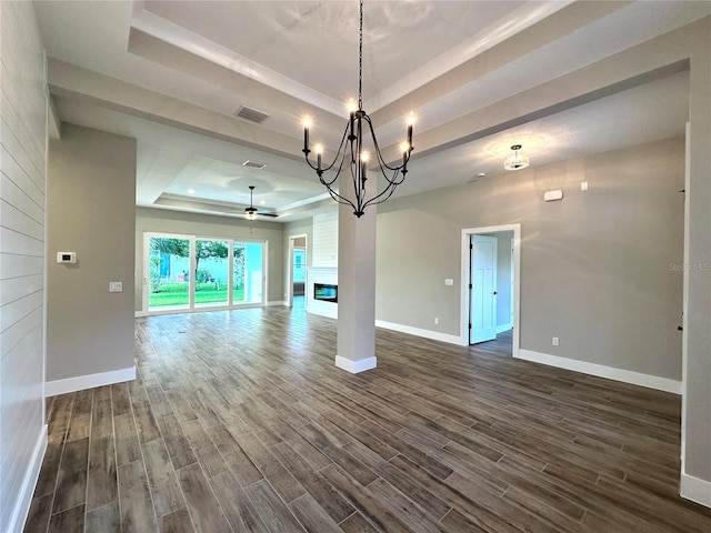 36 Armand Beach Dr, Palm Coast, FL 32137 - unfurnished living room with a raised ceiling, dark wood-style floors, ceiling fan, a chandelier, and a large fireplace
