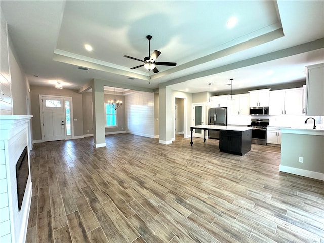 36 Armand Beach Dr, Palm Coast, FL 32137 - unfurnished living room with a raised ceiling, light wood-type flooring, a chandelier, ceiling fan, and recessed lighting