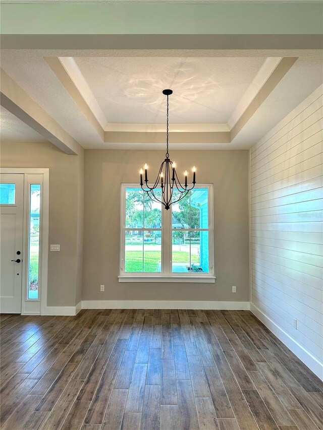 36 Armand Beach Dr, Palm Coast, FL 32137 - unfurnished dining area featuring a tray ceiling, dark wood-style flooring, a chandelier, and wood walls