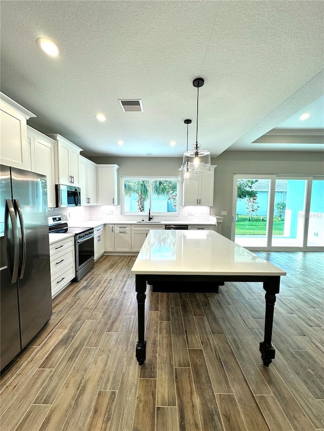 36 Armand Beach Dr, Palm Coast, FL 32137 - kitchen featuring stainless steel appliances, a kitchen breakfast bar, wood finished floors, light countertops, and recessed lighting