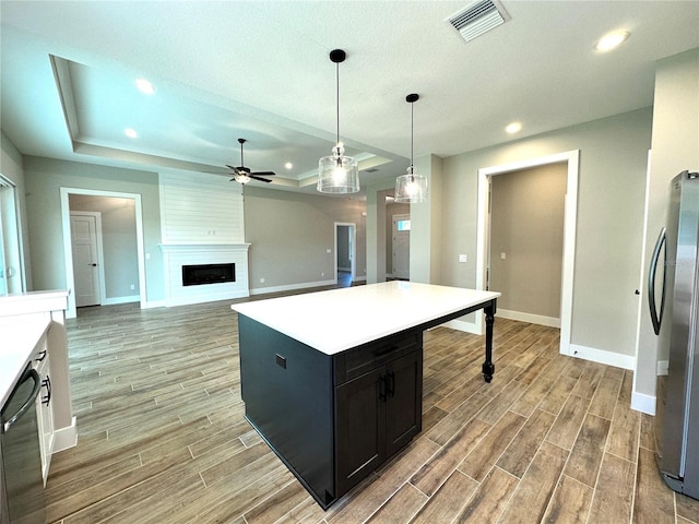 36 Armand Beach Dr, Palm Coast, FL 32137 - kitchen with freestanding refrigerator, a raised ceiling, ceiling fan, light wood-style flooring, and a fireplace