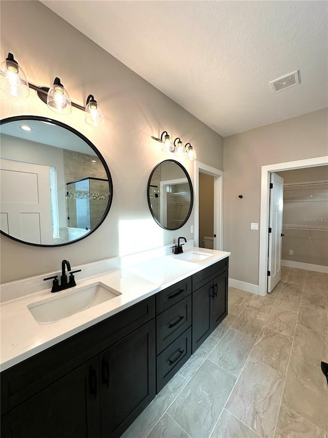 36 Armand Beach Dr, Palm Coast, FL 32137 - bathroom with double vanity, marble look tiles, a textured ceiling, and tiled shower