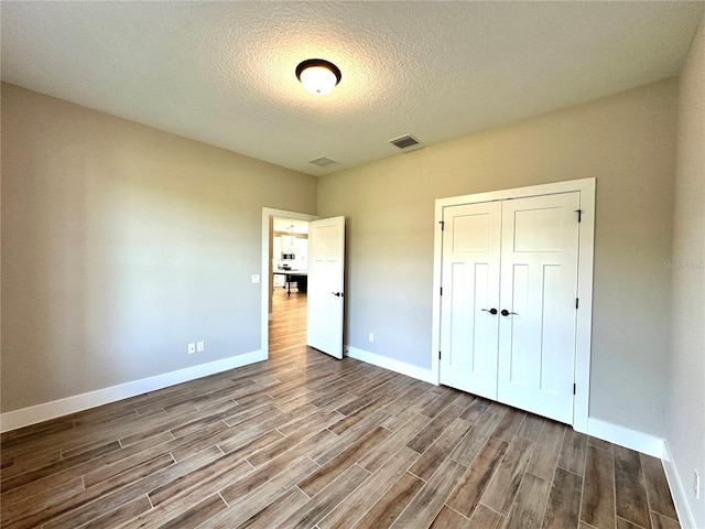 36 Armand Beach Dr, Palm Coast, FL 32137 - unfurnished bedroom featuring wood finished floors, a textured ceiling, and a closet